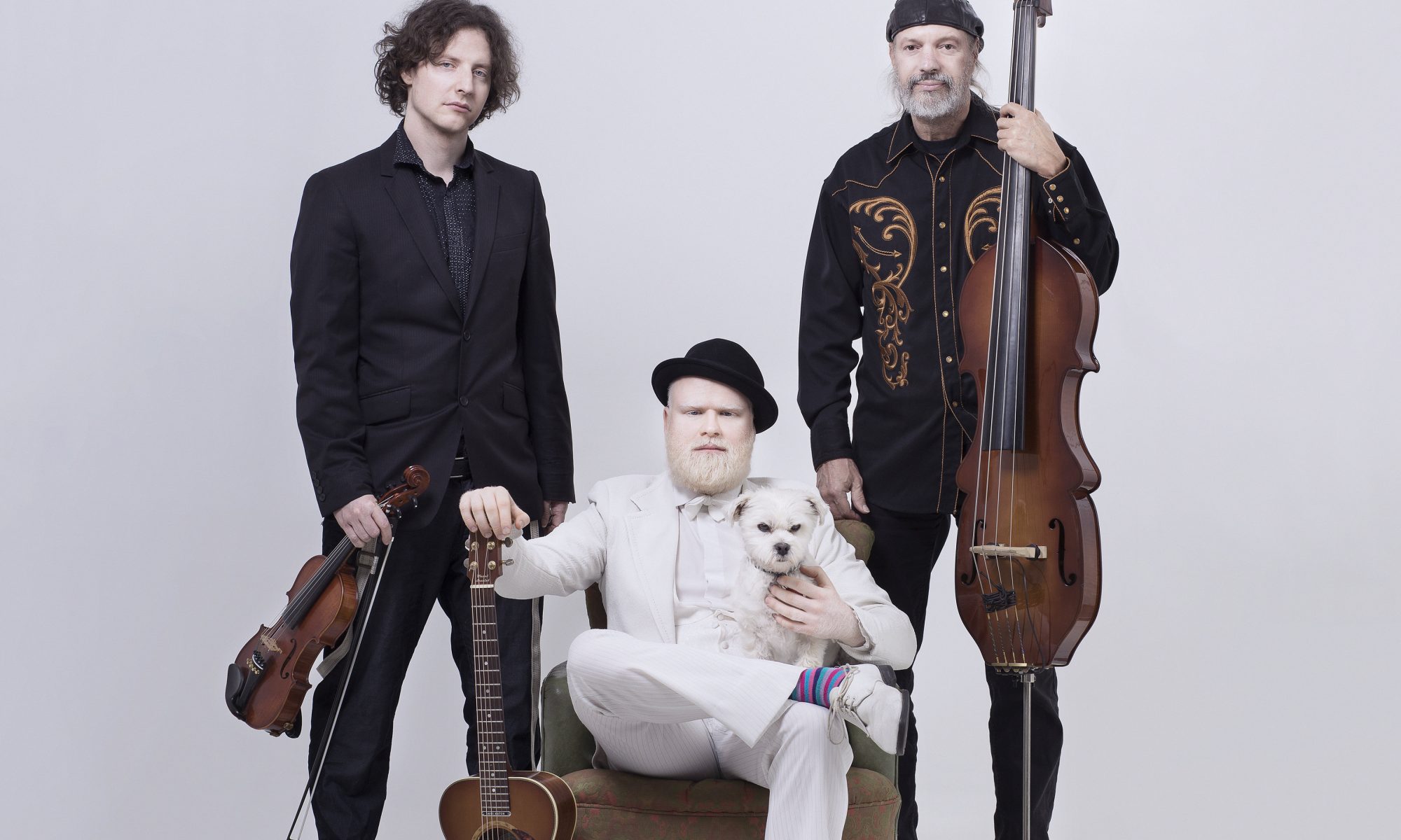 a rather eclectic photo of the 3 members of Albi & The Wolves against a white background holding their instruments.