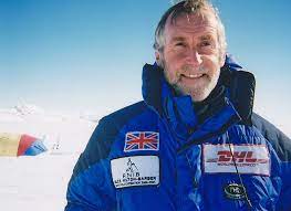 A photo of Miles in a blue parker against a blue-sky background