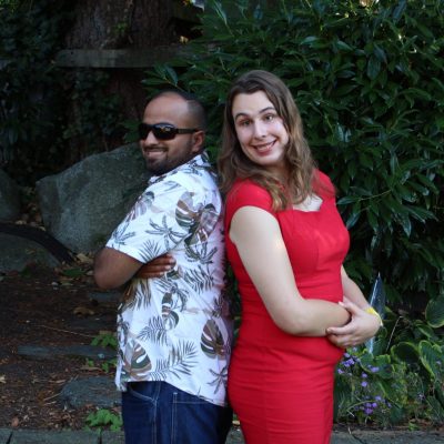 photo of Jugpreet Bajwa Sing, wearing a blue and white shirt and dark blue pants standing back to back with Justine Ongreen, waring a red